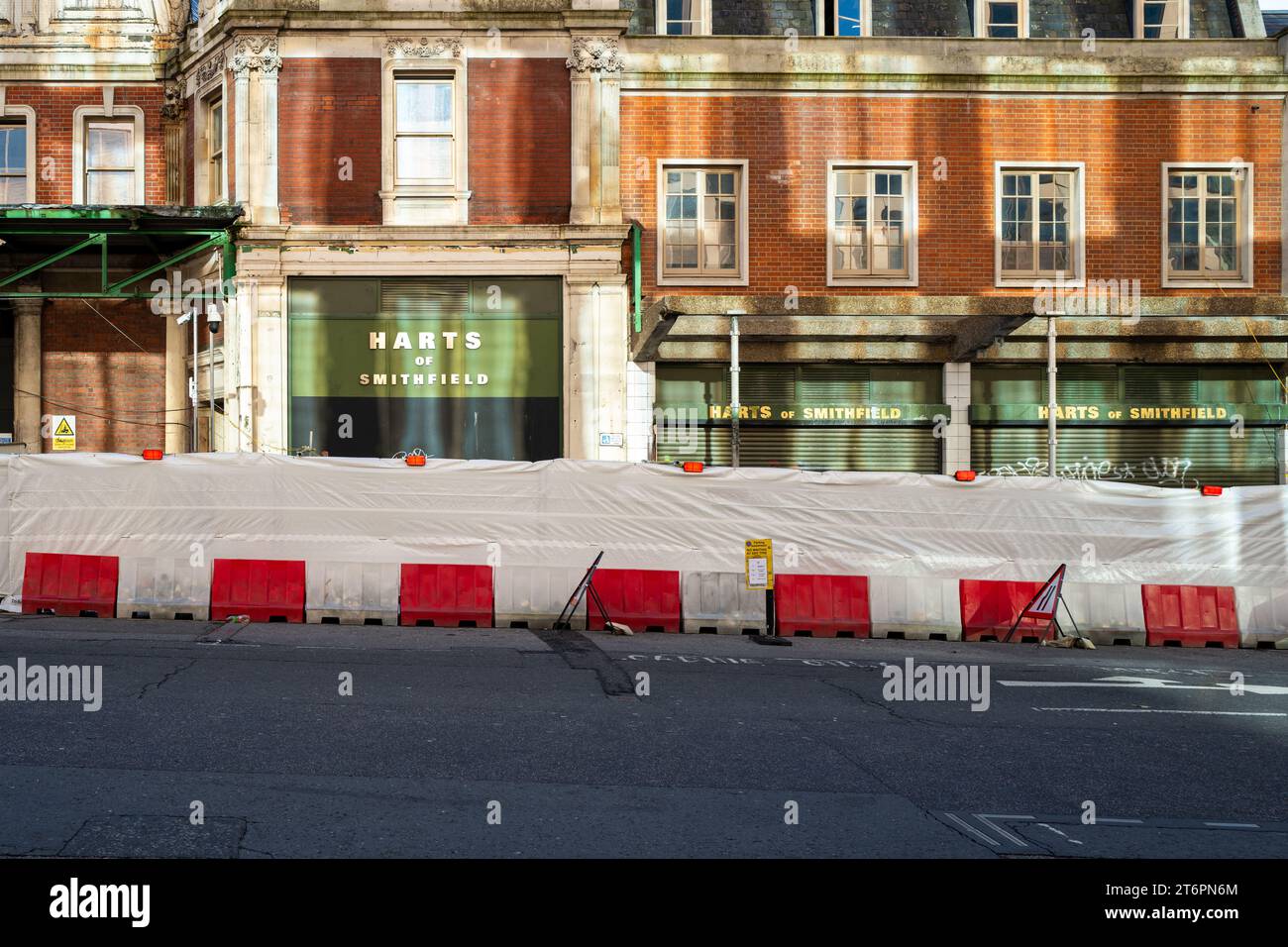 Harts of Smithfield, part of Smithfield Market, London, sits behind construction barriers during the redevelopment of the General Market buildings Stock Photo