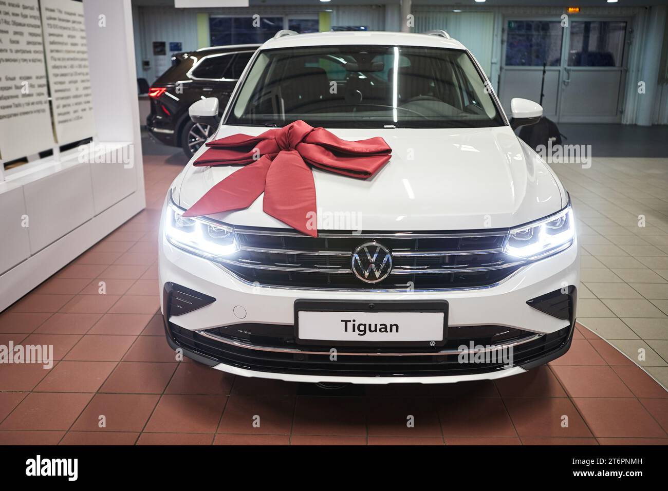 Vinnitsa, Ukraine - February 18, 2021. Volkswagen Tiguan with red bow - car presentation in showroom Stock Photo