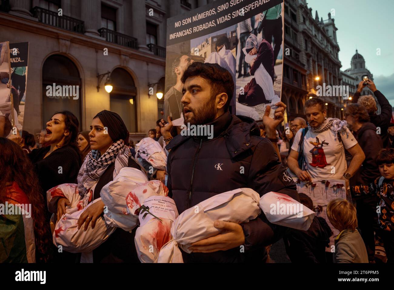 Barcelona, Spain. 11 November, 2023:  Demonstrators holding symbolic baby bodies to denounce the death of children during the Israeli attacks against Gaza in response to the attack by the Islamist movement Hamas from October 7 shout slogans against Israel during a demonstration in support of the Palestine people. Stock Photo