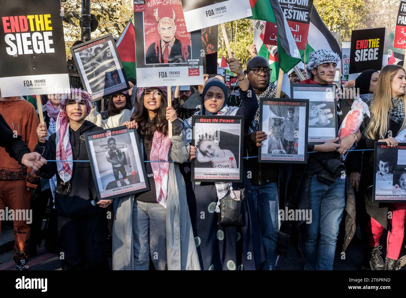 11th November 2023, London, UK. Hundreds of thousands of people march through central London in protest against Israel’s continued bombardment of Gaza. Organisers of the rally, the Palestine Solidarity Campaign, demand an immediate ceasefire. Pictured: Protestors display photographs of children identified as killed by Israel's bombardment of Gaza. Stock Photo
