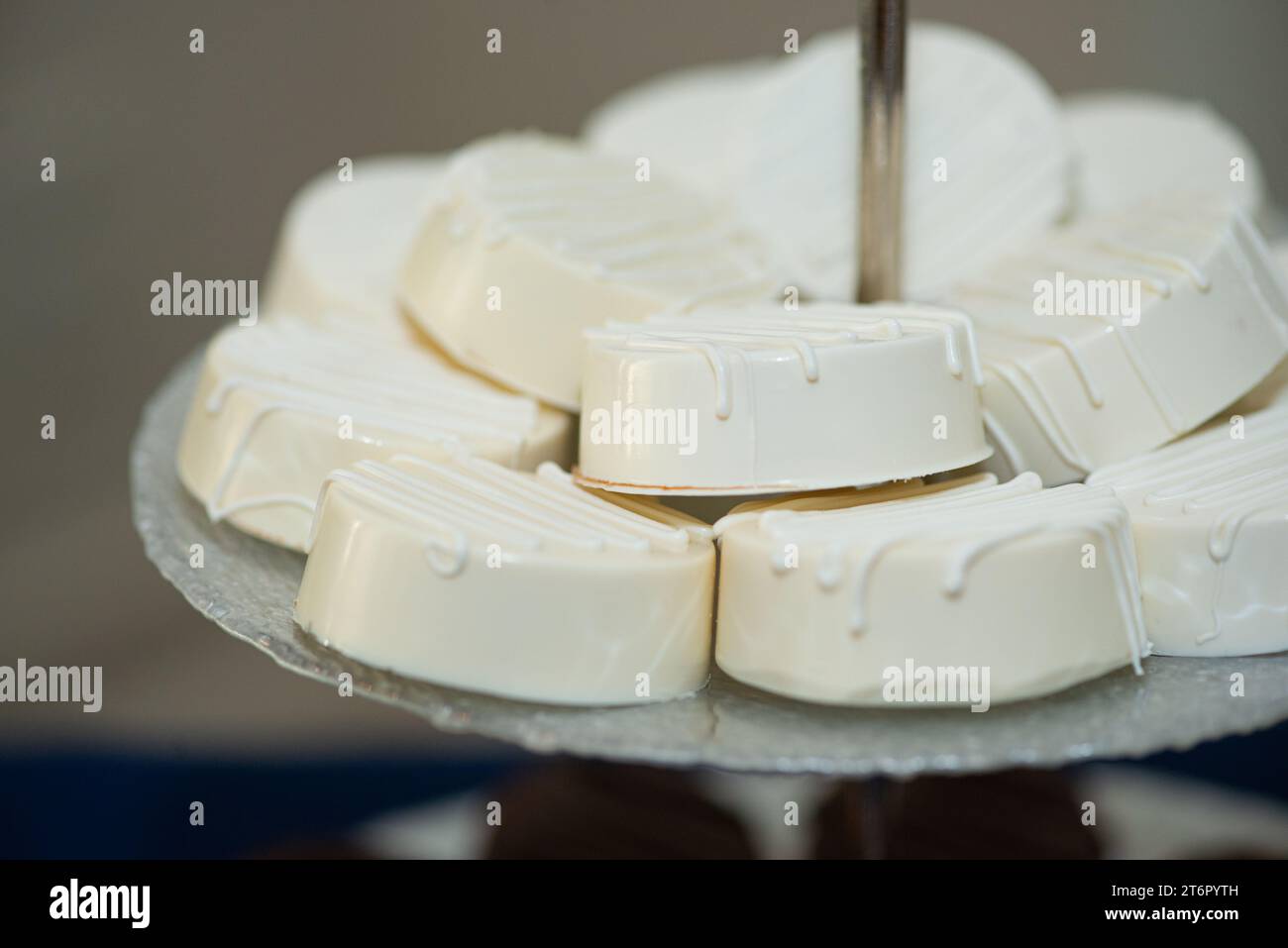 Vanilla Rounds Macadamia rounds covered in vanilla frosting on tray at dessert bar ...