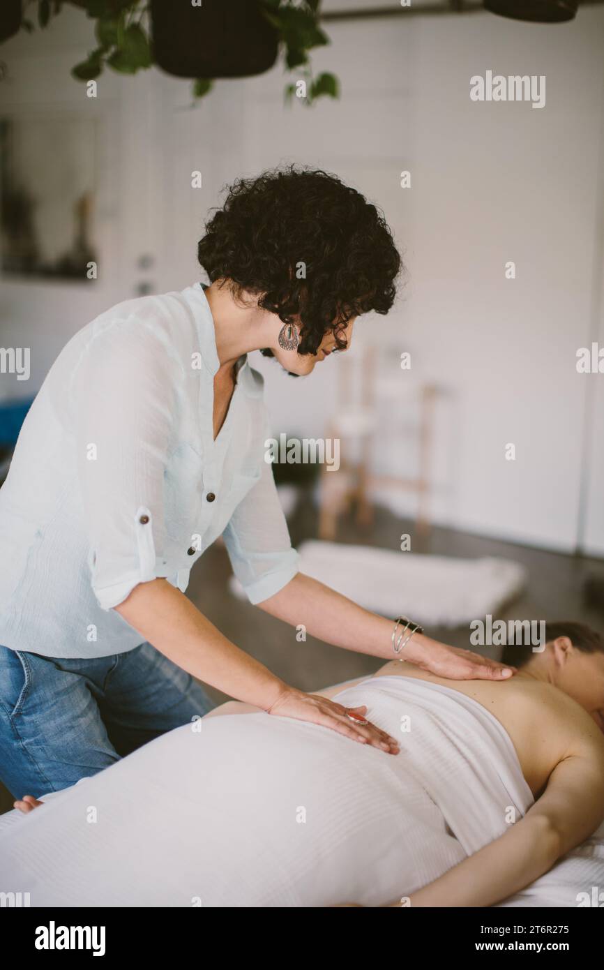 A female masseuse providing a therapeutic massage, focused on relaxation and relieving stress Stock Photo