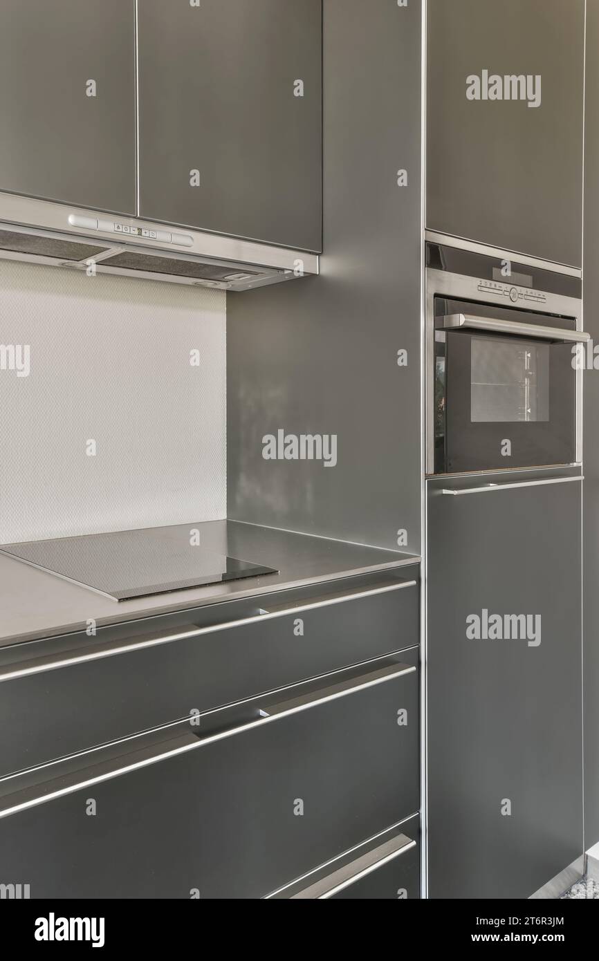 a modern kitchen with grey cabinets and stainless steel appliances on ...