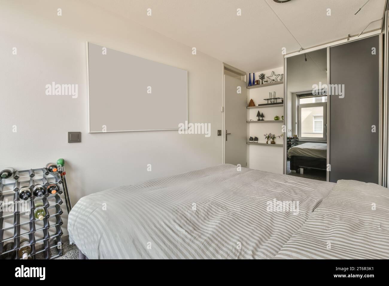 a bedroom with a bed, desk and shelves on the wall behind it is an open ...