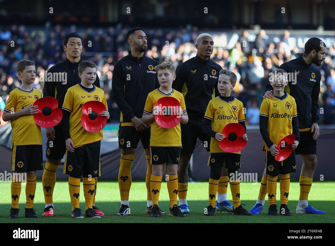 Wolverhampton Wanderers players line up as mascot hold large Remembrance Poppies during the Premier League match Wolverhampton Wanderers vs Tottenham Hotspur at Molineux, Wolverhampton, United Kingdom, 11th November 2023  (Photo by Gareth Evans/News Images) Stock Photo