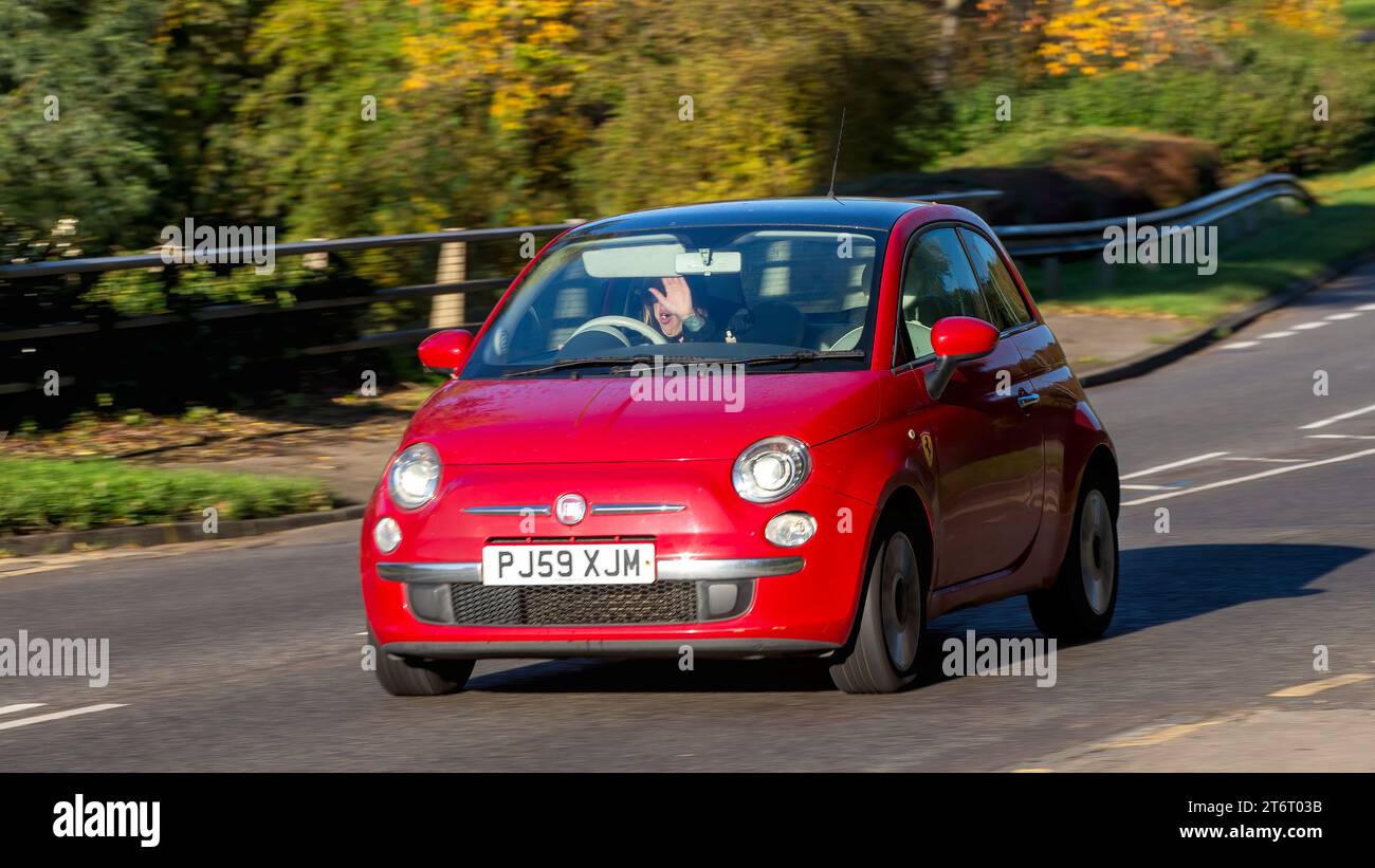 Milton Keynes,UK - Nov 11th 2023: 2009 red Fiat 500 car driving on an English road.Driver has the Sun in their eyes Stock Photo