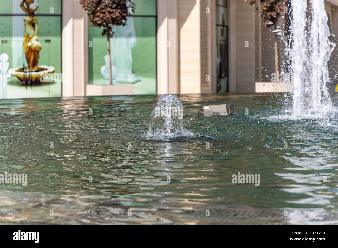 Water fountain with splashes of water for relaxation and coolness of the city and parks. Stock Photo