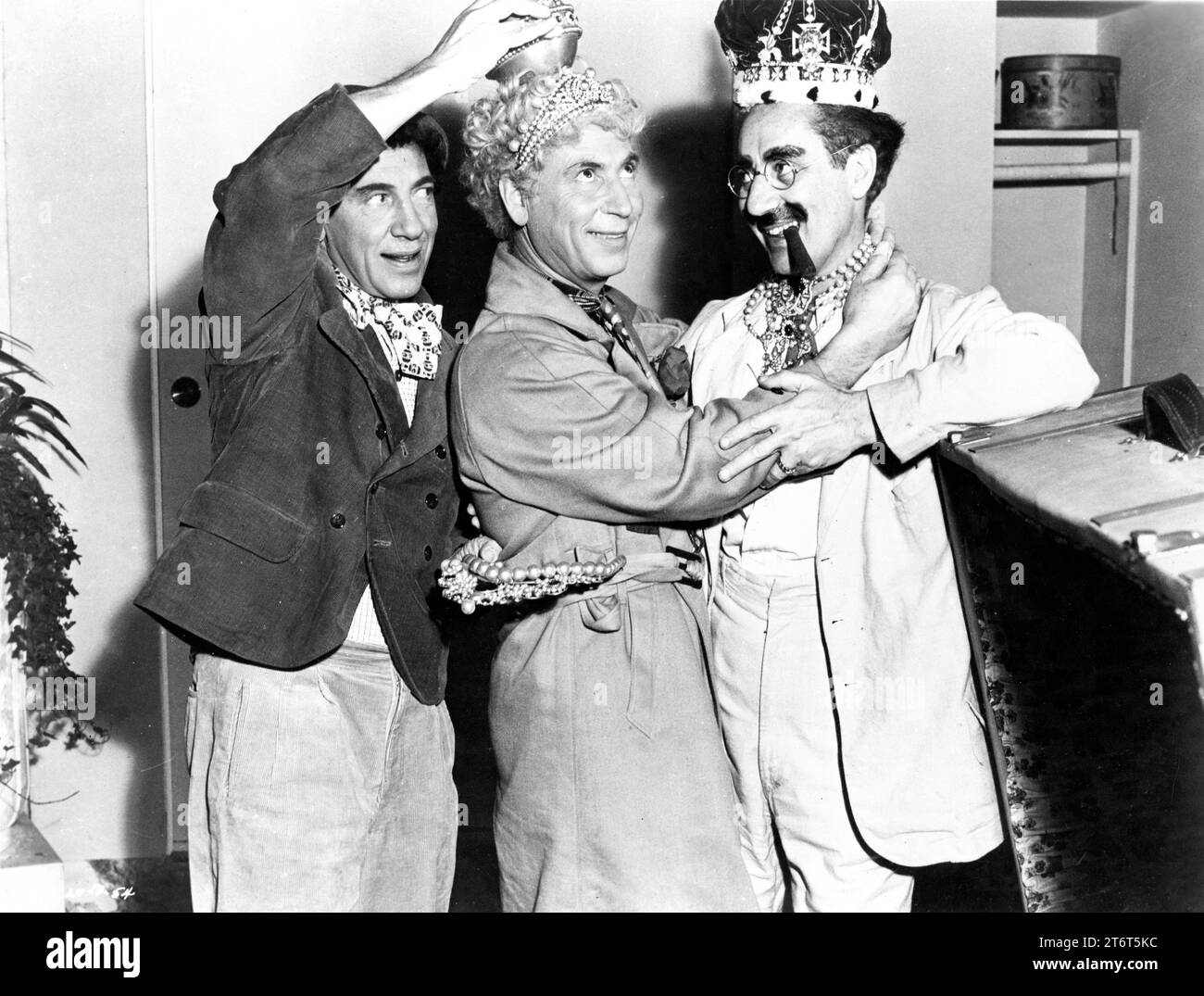 THE MARX BROTHERS CHICO HARPO and GROUCHO on set candid gag shot with jewels during filming of A NIGHT IN CASABLANCA 1946 director ARCHIE L. MAYO producer David L. Loew Loma Vista Productions / United Artists Stock Photo