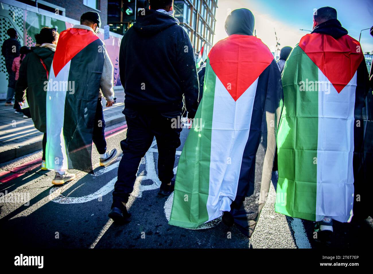 Protestors wear the Palestinian flag during the National March For Palestine Ceasefire Now! Protest. Organizers called for a ceasefire which is rooted in a sincere wish to see an end to all violence, especially that which targets civilians while recognizing that this cannot be achieved unless the root causes of that violence, the 75 years of ongoing Nakba against the Palestinian people, are adequately addressed. Stock Photo
