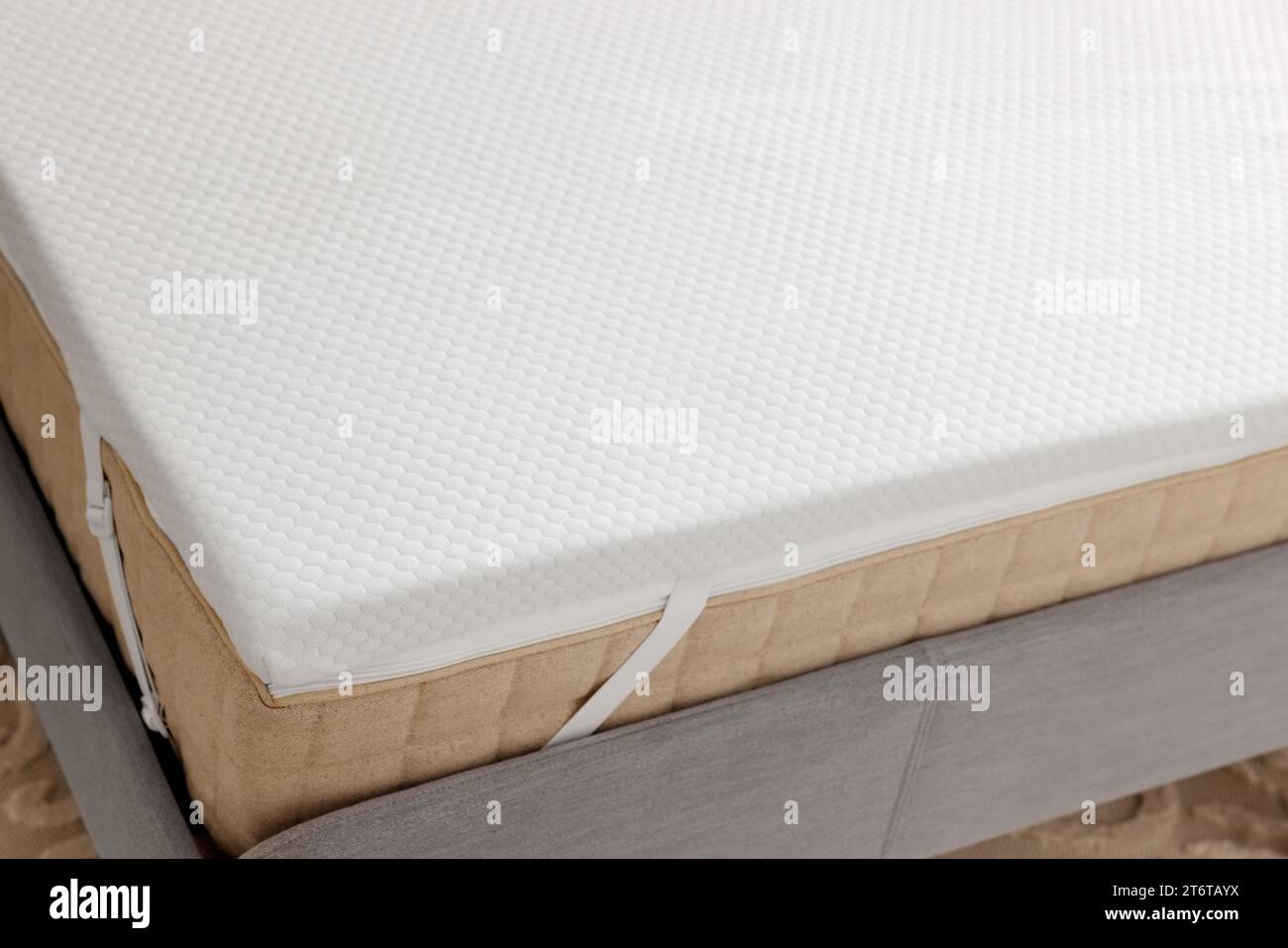 https://c8.alamy.com/comp/2T6TAYX/white-memory-foam-mattress-topper-on-grey-bed-2T6TAYX.jpg