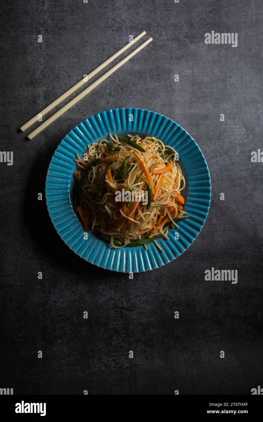 Top view of Schezwan noodles or vegetable hakka chowmein served in a bowl. Selective focus. Stock Photo