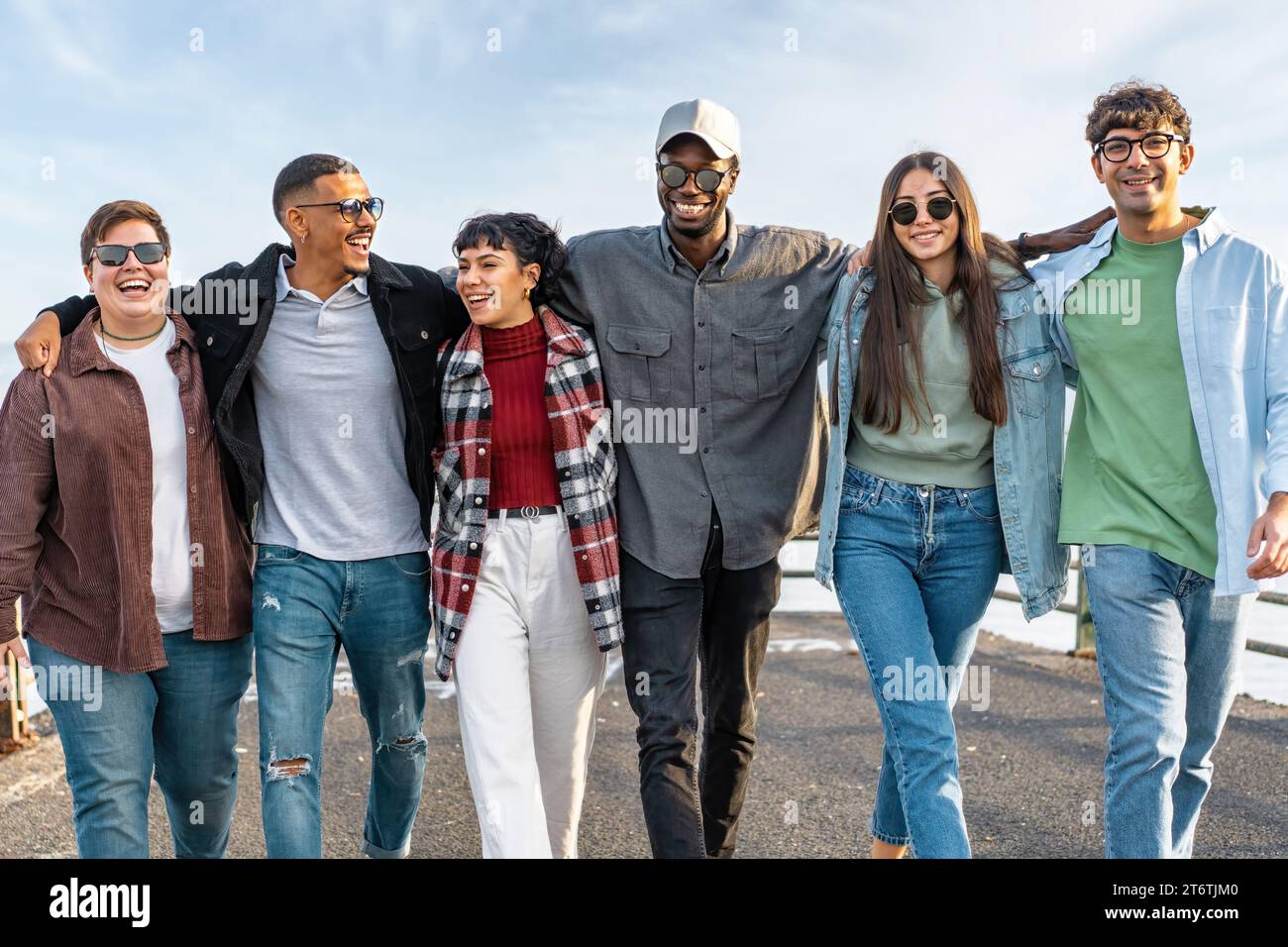 Group of young, diverse friends walking and laughing together ...