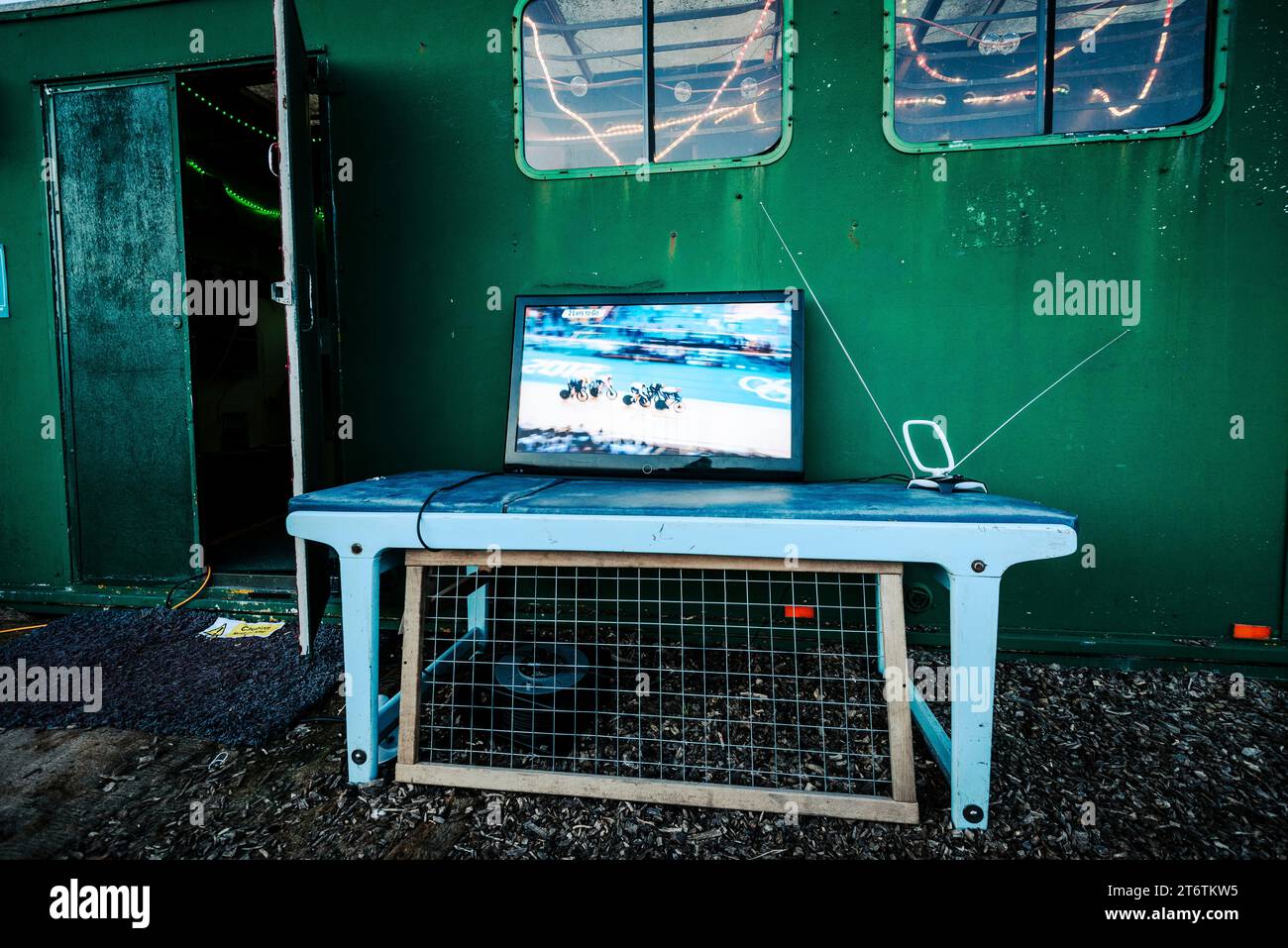 An old flat TV sits on a table outside a green hut at a campsite in West Wales UK Stock Photo