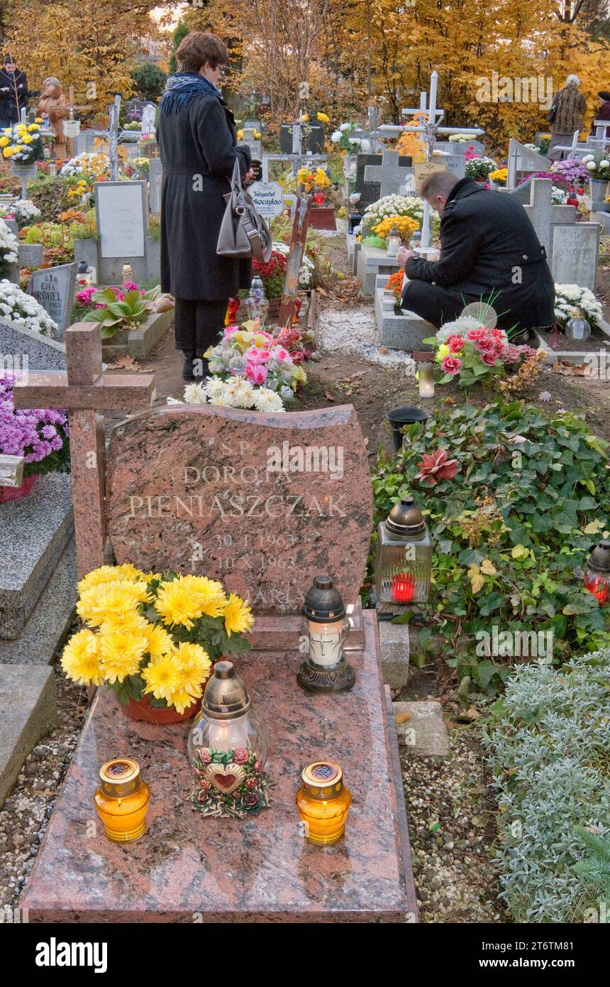 Visiting child's grave on All Saints Day at small children section at Saint Lawrence Cemetery in Wroclaw, Lower Silesia, Poland Stock Photo