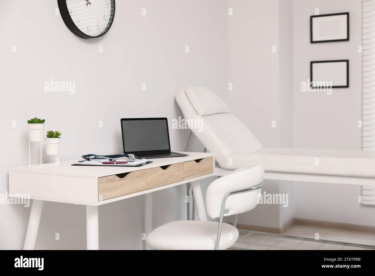 Modern medical office with doctor's workplace and examination table in ...
