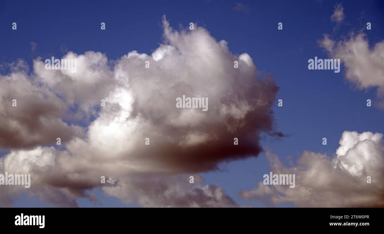 Blue sky with gloomy black clouds and sun rays Stock Photo
