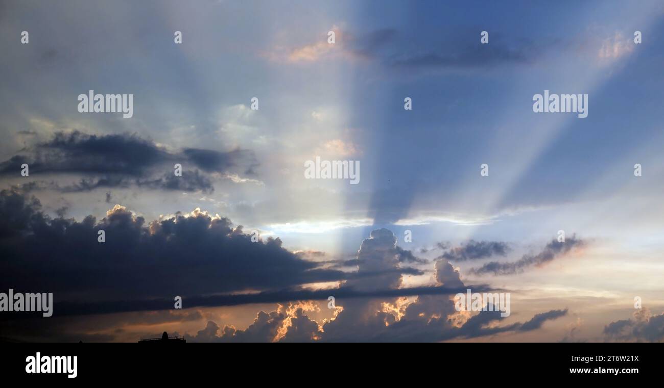 Blue sky with gloomy black clouds and sun rays Stock Photo - Alamy
