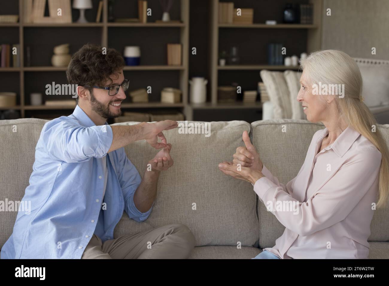 Millennial grown up son communicates with older mother using gestures Stock Photo