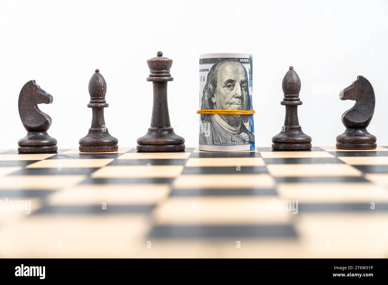 Chess board with one line of selected black figures, American banknotes ...