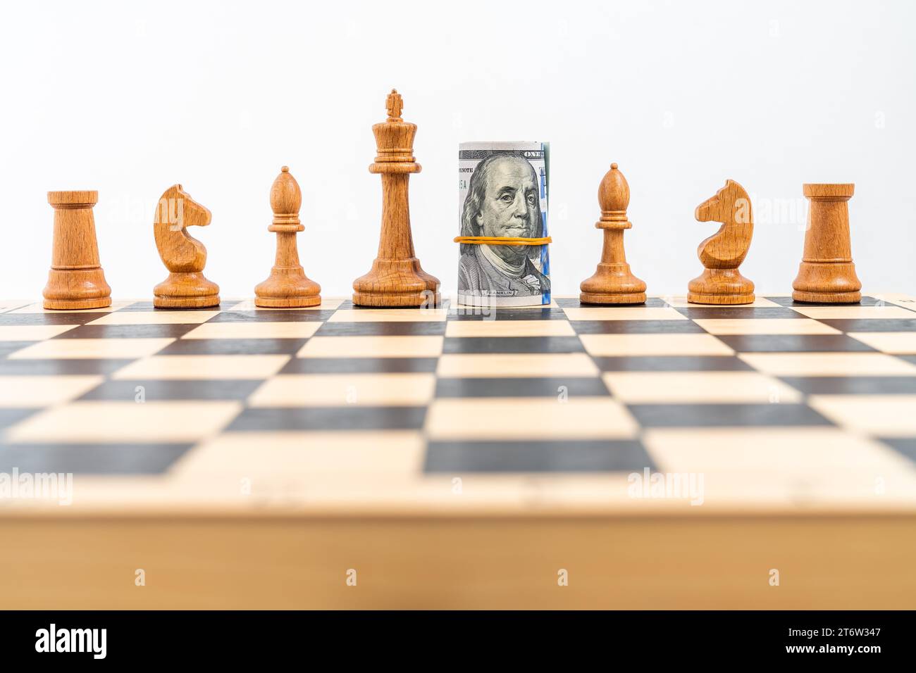 Chess board with one line of white figures, American banknotes rolled ...