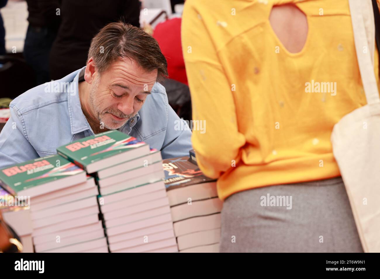 Brive-la-Gaillarde, France. November 12, 2023. Michel Bussi successful French writer dedicates his books at the famous Brive Book Fair (Foire du livre de Brive). Michel Bussi has a literary career of major importance, particularly in the field of detective novels. He is one of the best-selling French writers. Michel Bussi's novels are translated into more than 35 languages and are particularly popular in the United Kingdom, Italy, China, Brazil, Russia... Brive-la-Gaillarde, Corrèze, France, Europe. Photo HM Images/Alamy Live News. Stock Photo