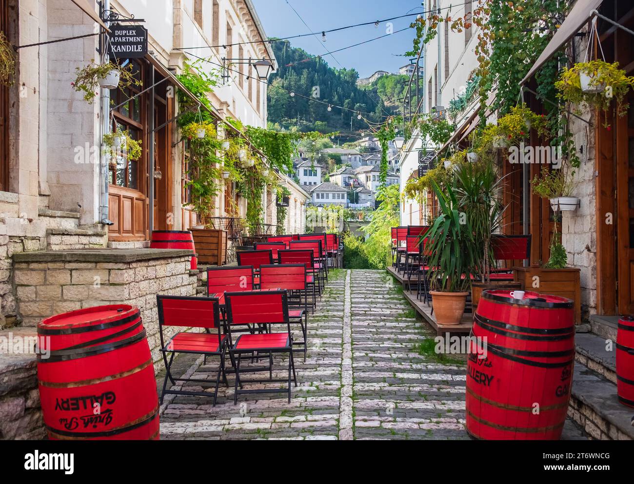 Outdoor empty coffee and restaurant terrace with colorful tables and chairs. Old fashioned cafe terrace in Berat Albania. Restaurant patio furniture. Stock Photo