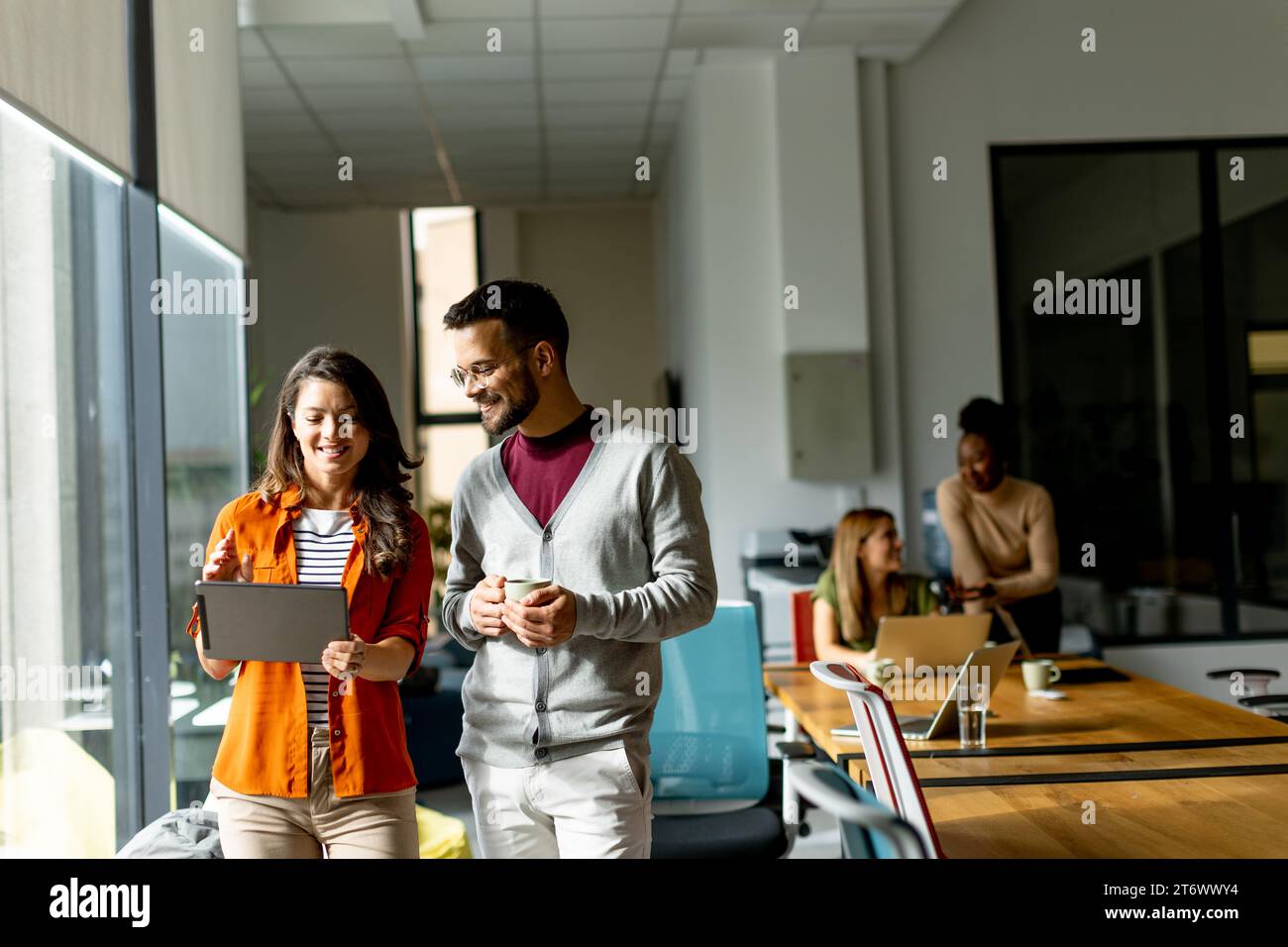 Young business couple standing with digital tablet in front of her team at the modern office Stock Photo