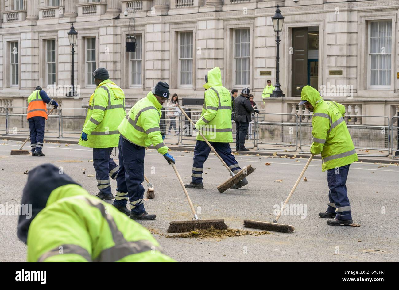 Men in Whitehall, Westminster clear up after the horses following Charles III's first State Opening of Parliament as king. 7th November 2023 Stock Photo