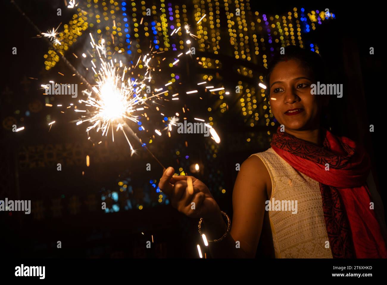 Woman light phuljhari or stick firecracker, on the occasion of Diwali