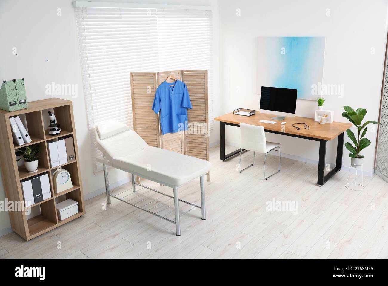 Modern medical office with doctor's workplace and examination table in ...