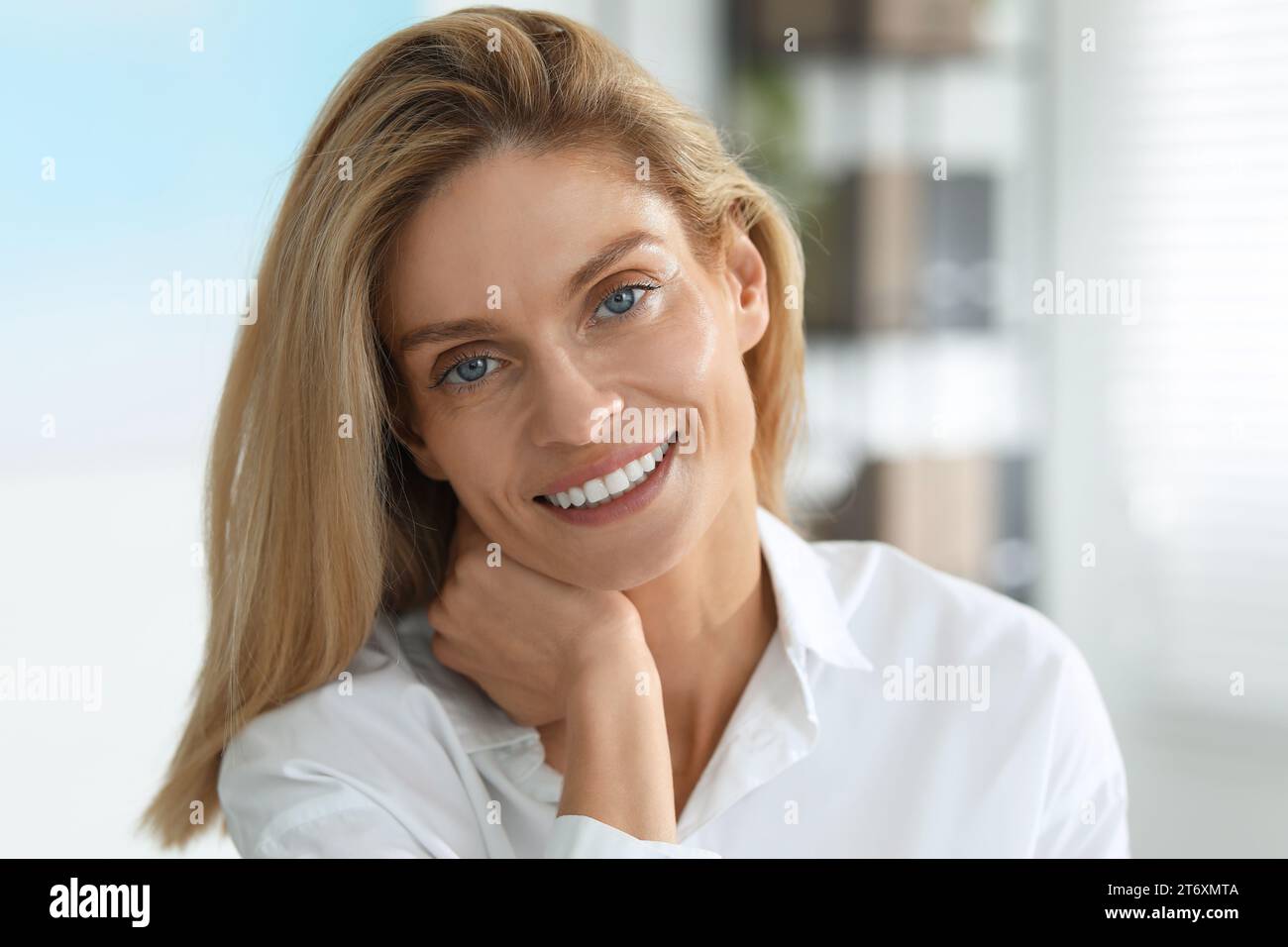 Portrait of smiling woman in formal clothes. Charming blonde lady posing indoors Stock Photo