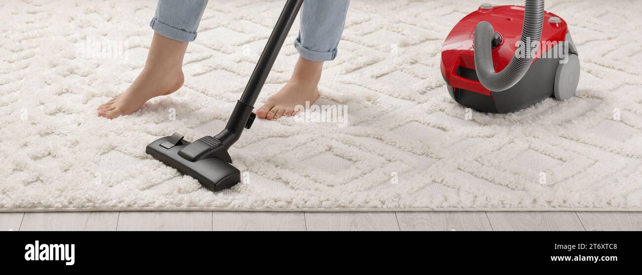 Woman cleaning carpet with vacuum cleaner at home, closeup. Banner design Stock Photo