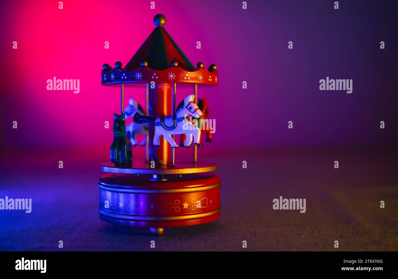 Merry-go-round toy with Christmas motifs with colorful blue and magenta lighting Stock Photo