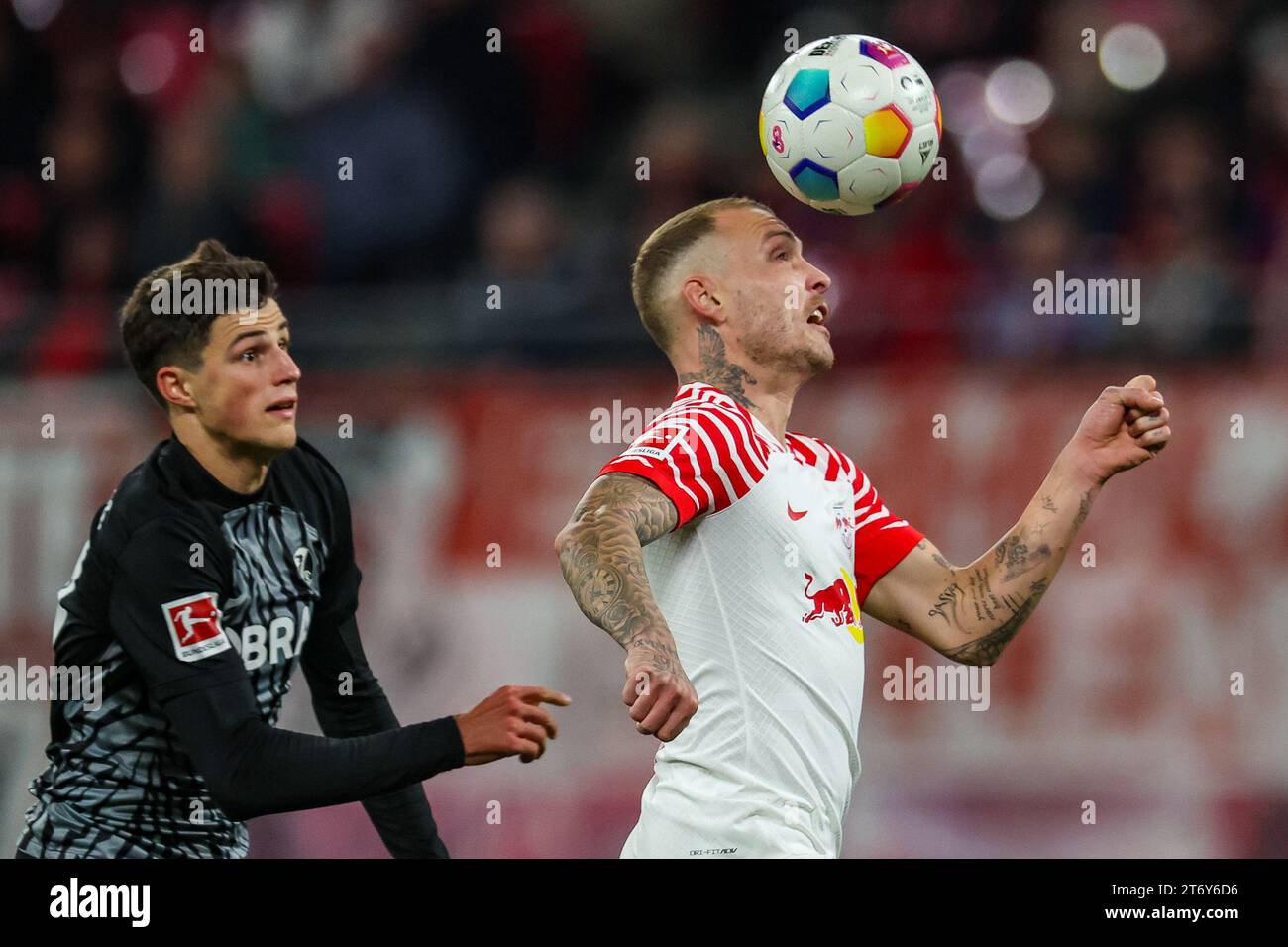 12 November 2023, Saxony, Leipzig: Soccer: Bundesliga, matchday 11, RB Leipzig - SC Freiburg at the Red Bull Arena. Leipzig's David Raum (r) and Freiburg's Merlin Röhl in a duel. Photo: Jan Woitas/dpa - IMPORTANT NOTE: In accordance with the regulations of the DFL German Football League and the DFB German Football Association, it is prohibited to utilize or have utilized photographs taken in the stadium and/or of the match in the form of sequential images and/or video-like photo series. Stock Photo