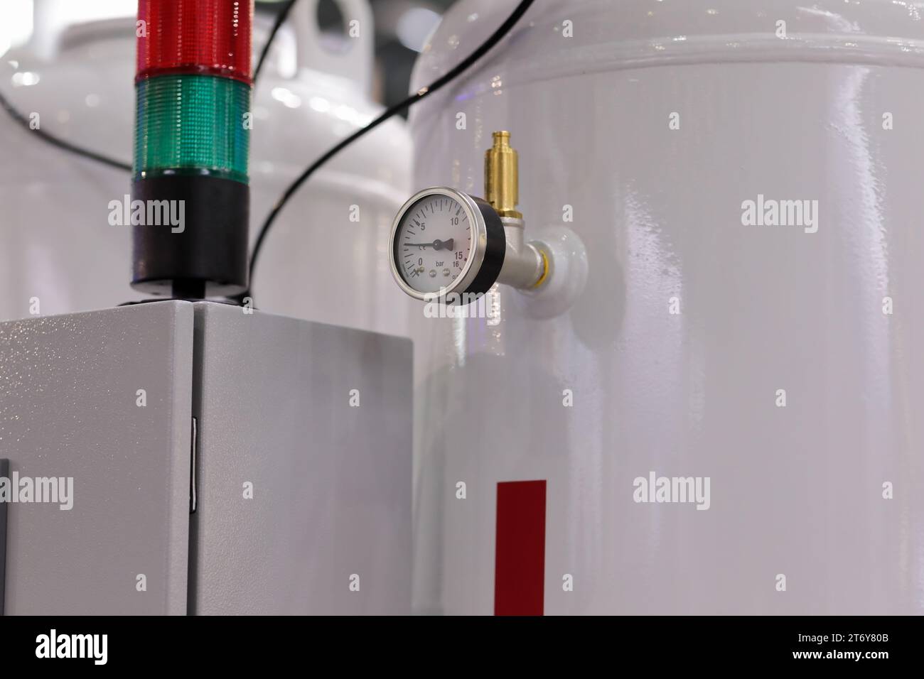 Industrial manufacturing equipment closeup concept. Gas cylinders with preswsure gauge. Control cabinet with tower signal lights. Selective focus. Stock Photo
