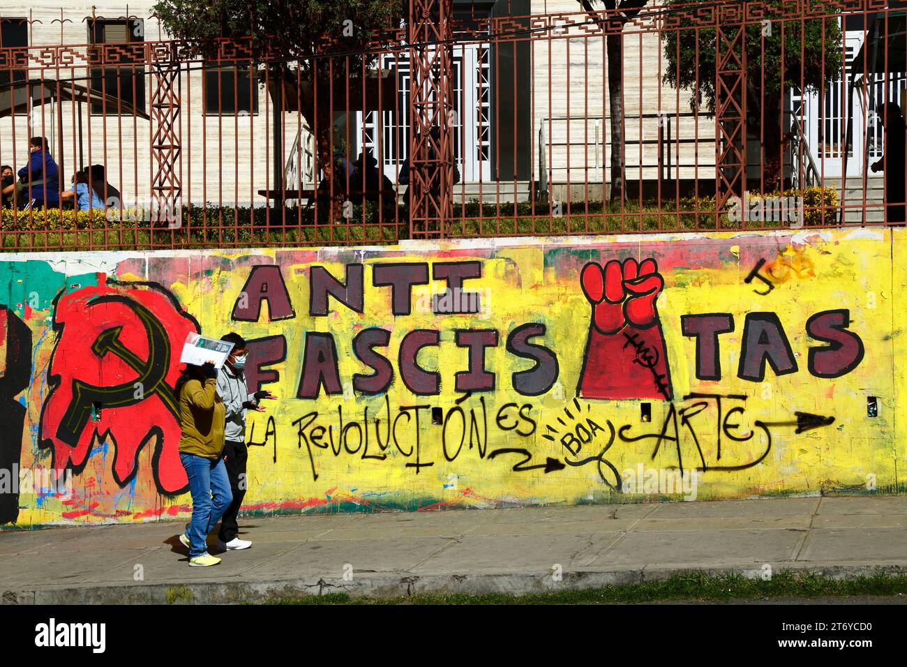 Students walk past an anti fascists mural by the Bolivian Communist Party near the main UMSA university in central La Paz, Bolivia Stock Photo