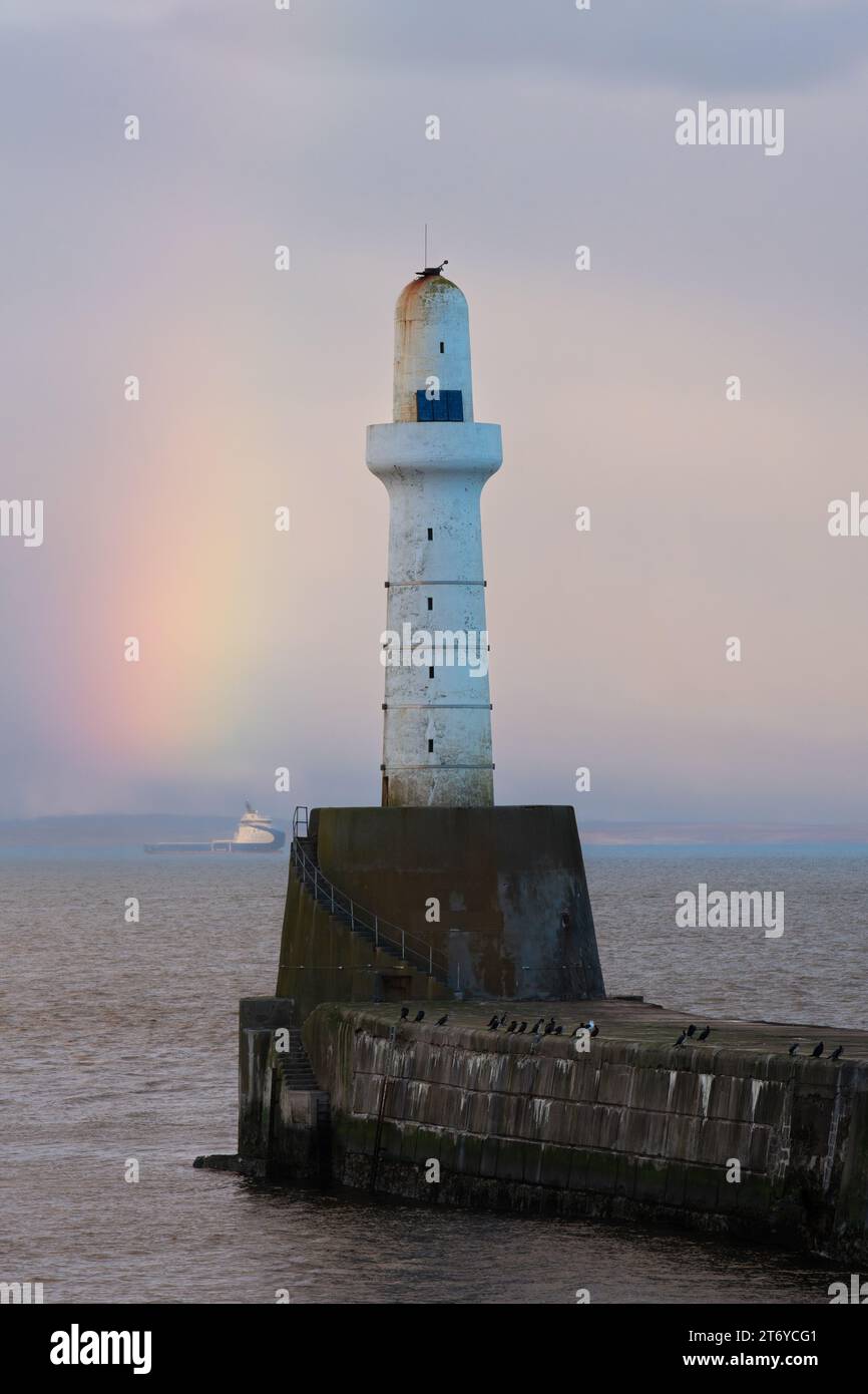 Aberdeen South Breakwater Head Lighthouse and rainbow at the entrance to Aberdeen Harbour, Aberdeen, Scotland, UK Stock Photo