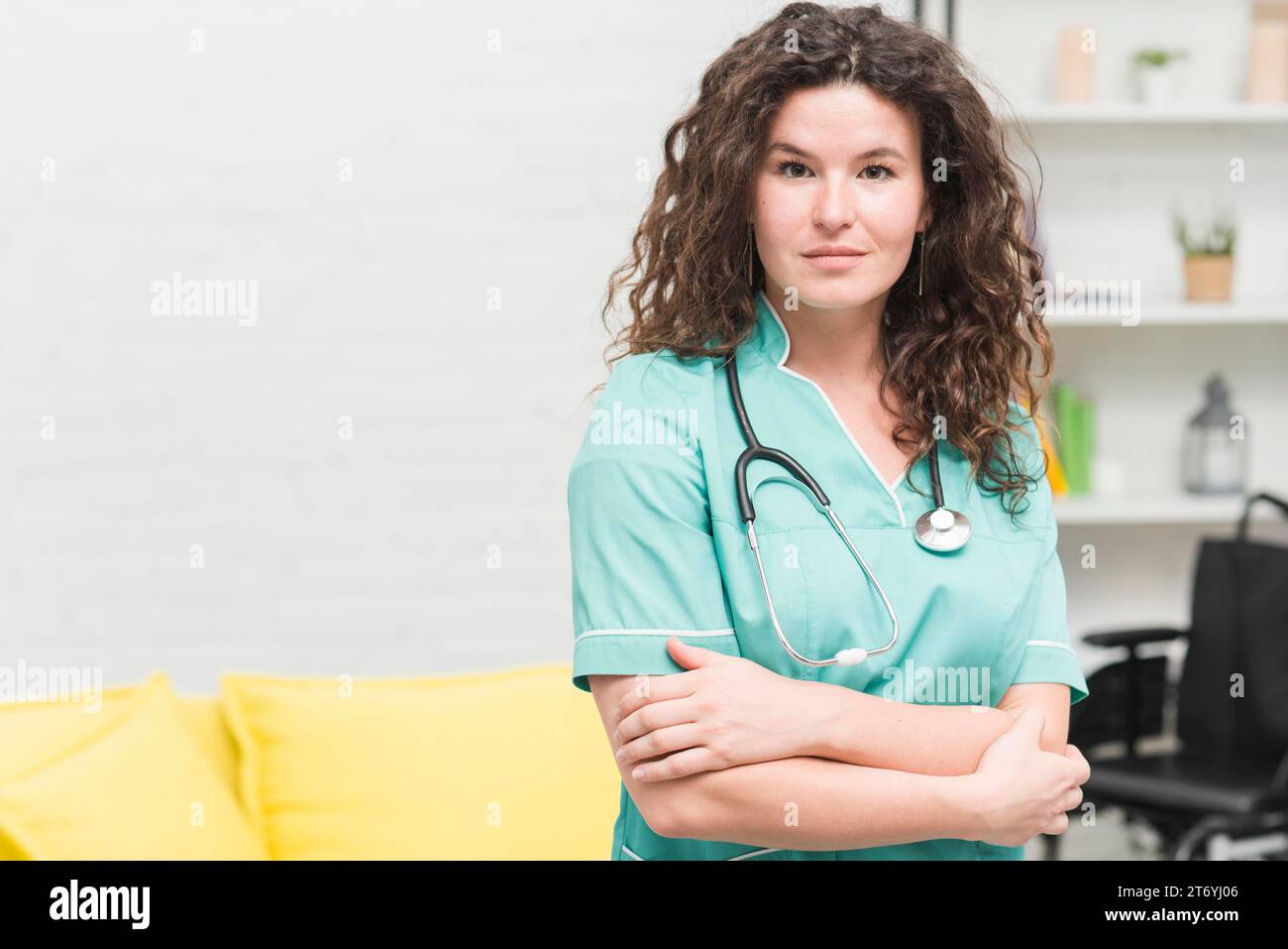Young woman with stethoscope around her neck standing hospital Stock Photo