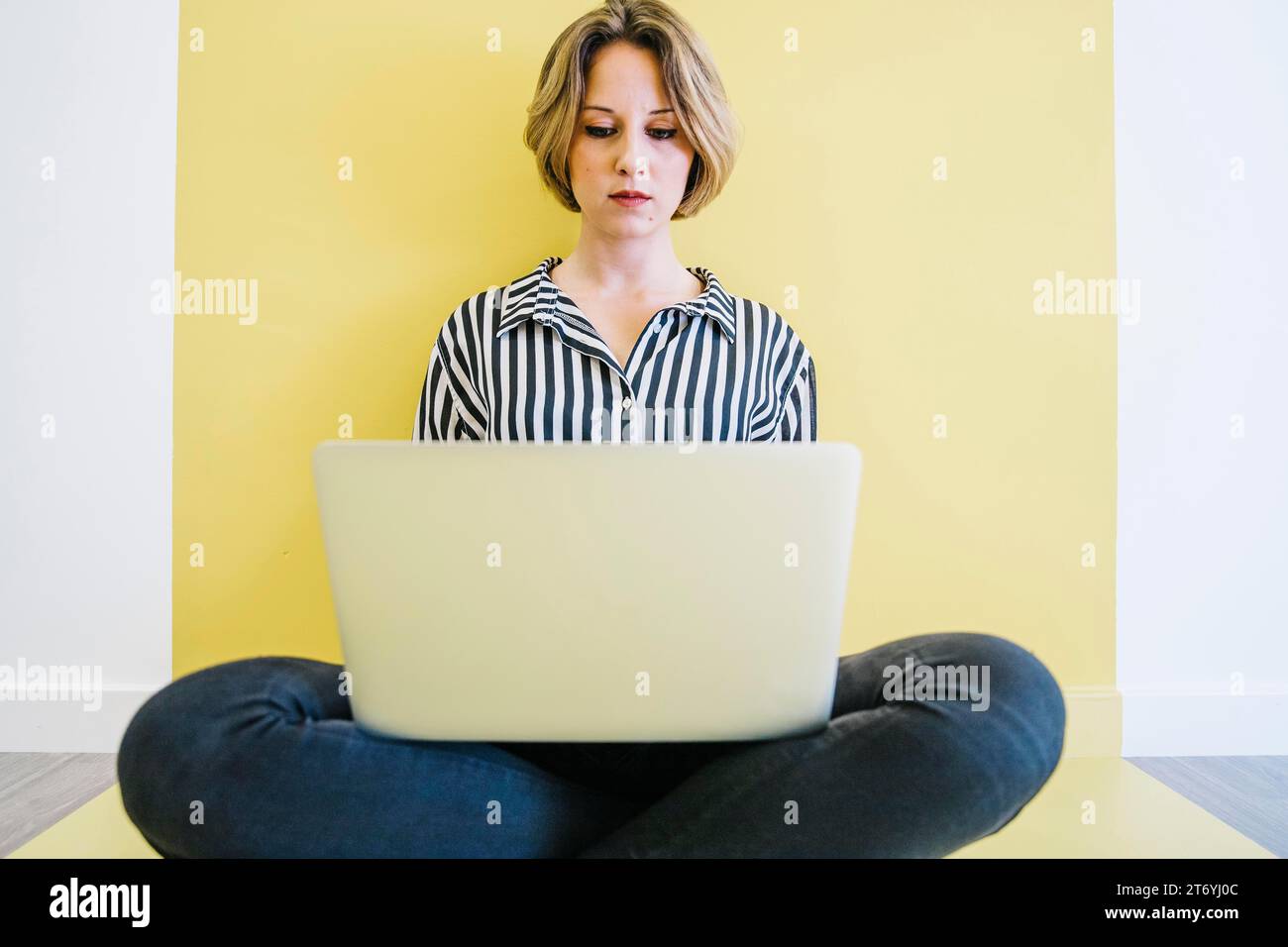 Young woman browsing laptop floor Stock Photo - Alamy
