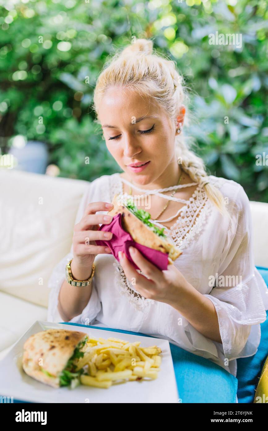 Close up young woman eating sandwiches Stock Photo - Alamy