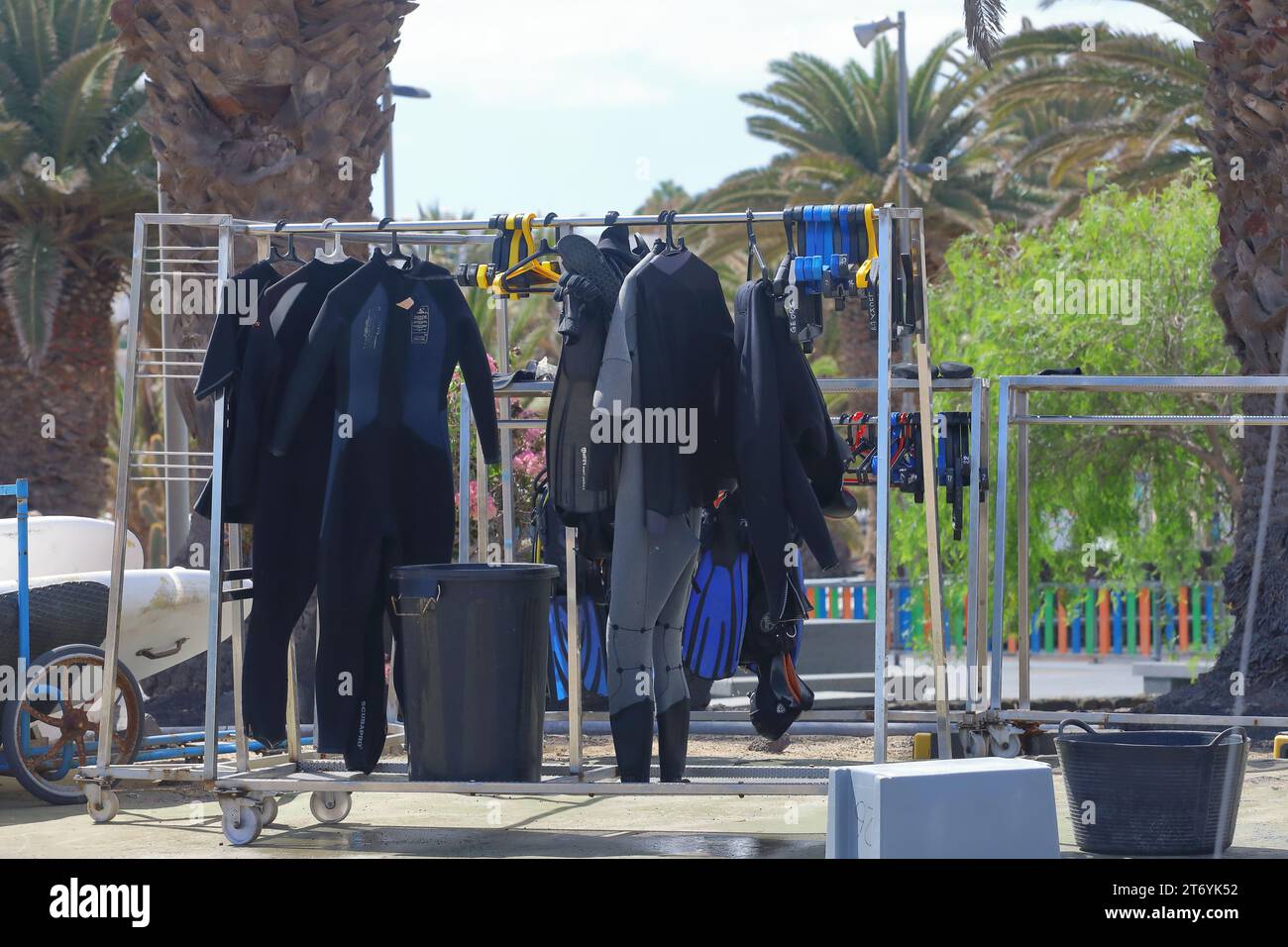 a rack full of wet suits drying Stock Photo