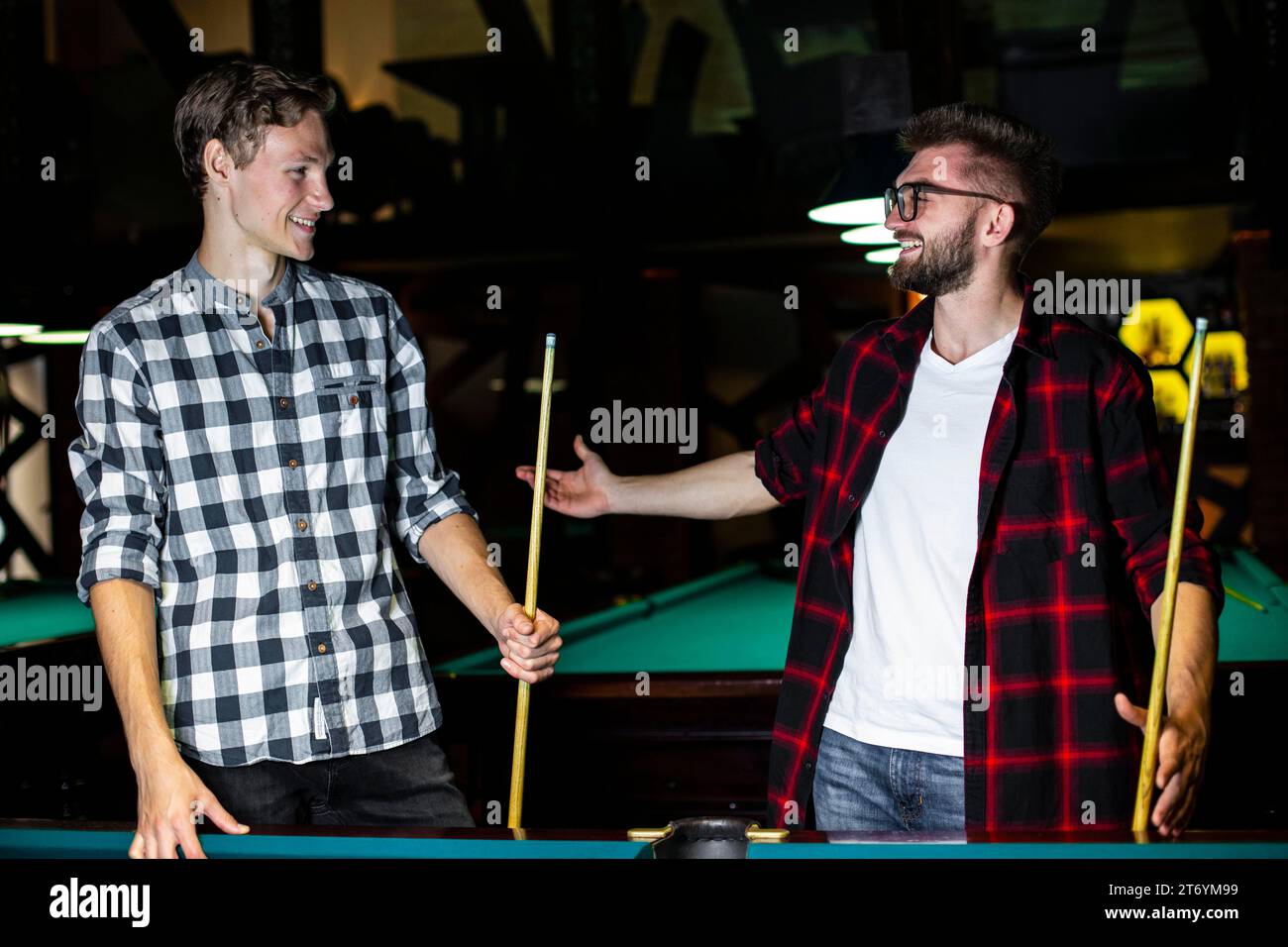 Medium shot smiley guys with pool cues Stock Photo