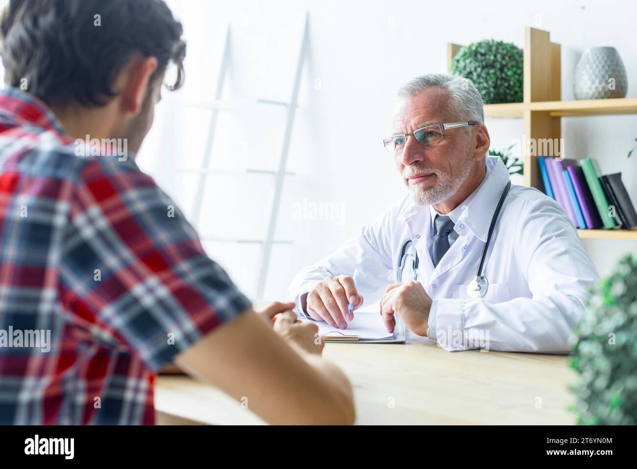 Senior doctor listening patient closely Stock Photo