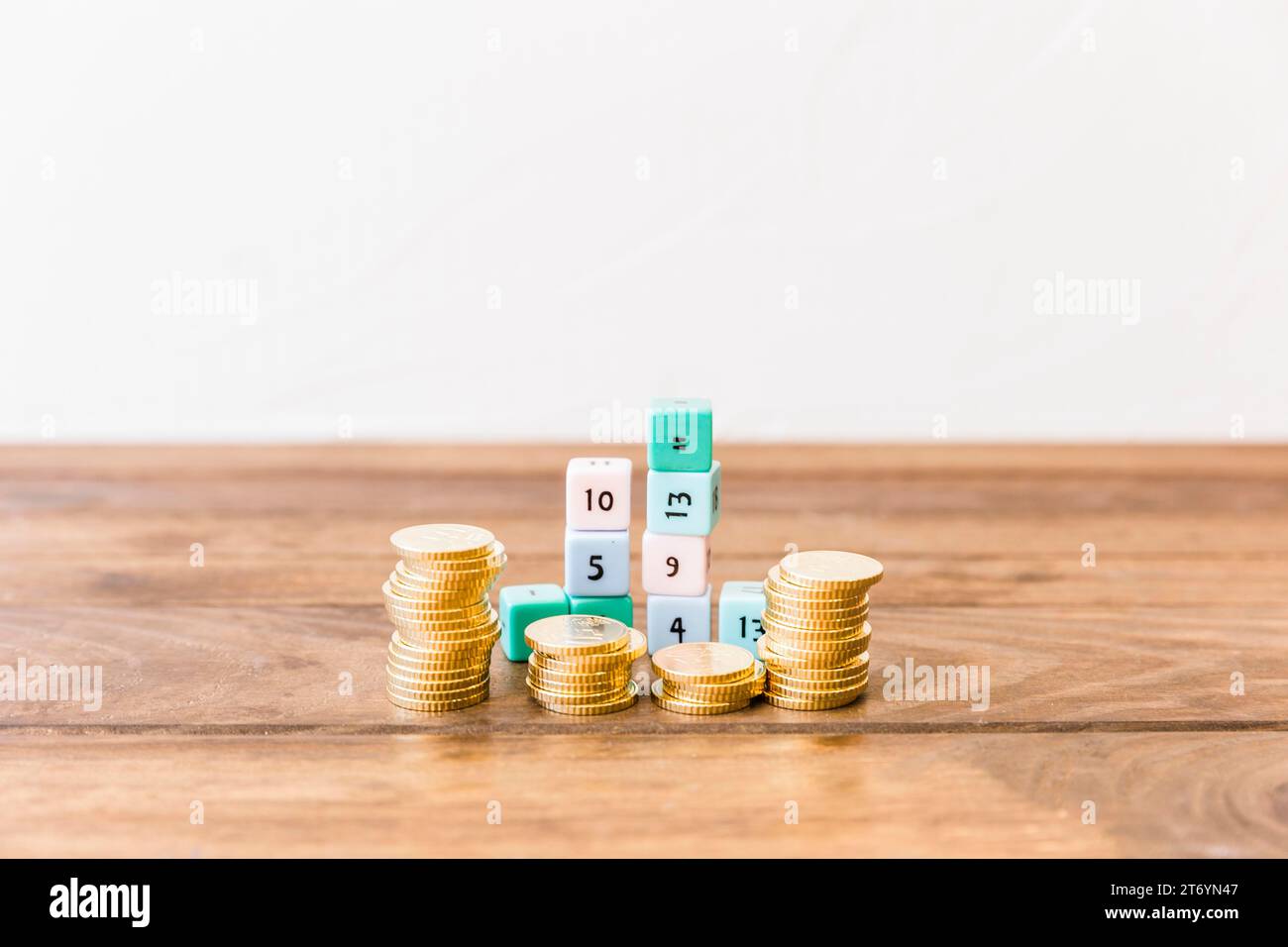 Stacked coins math blocks wooden tabletop Stock Photo - Alamy