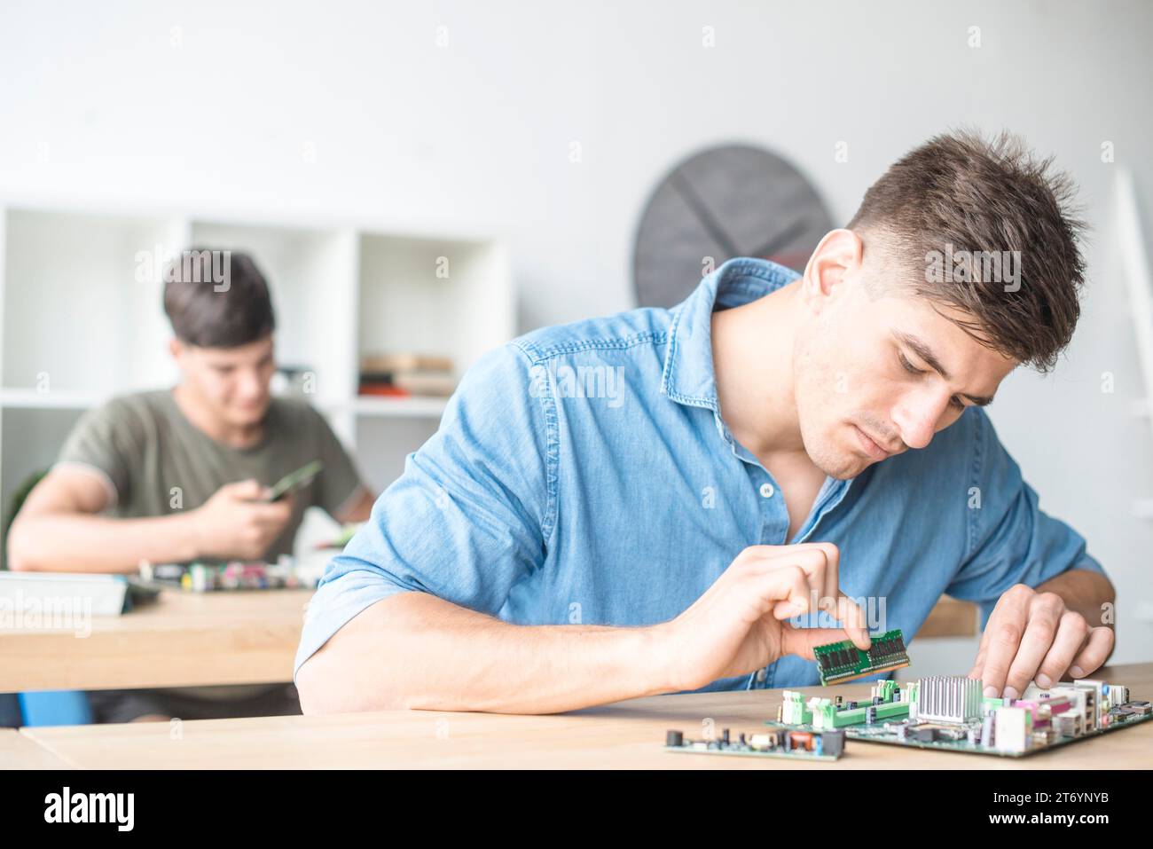 Young male it technician fixing ram motherboard slot Stock Photo