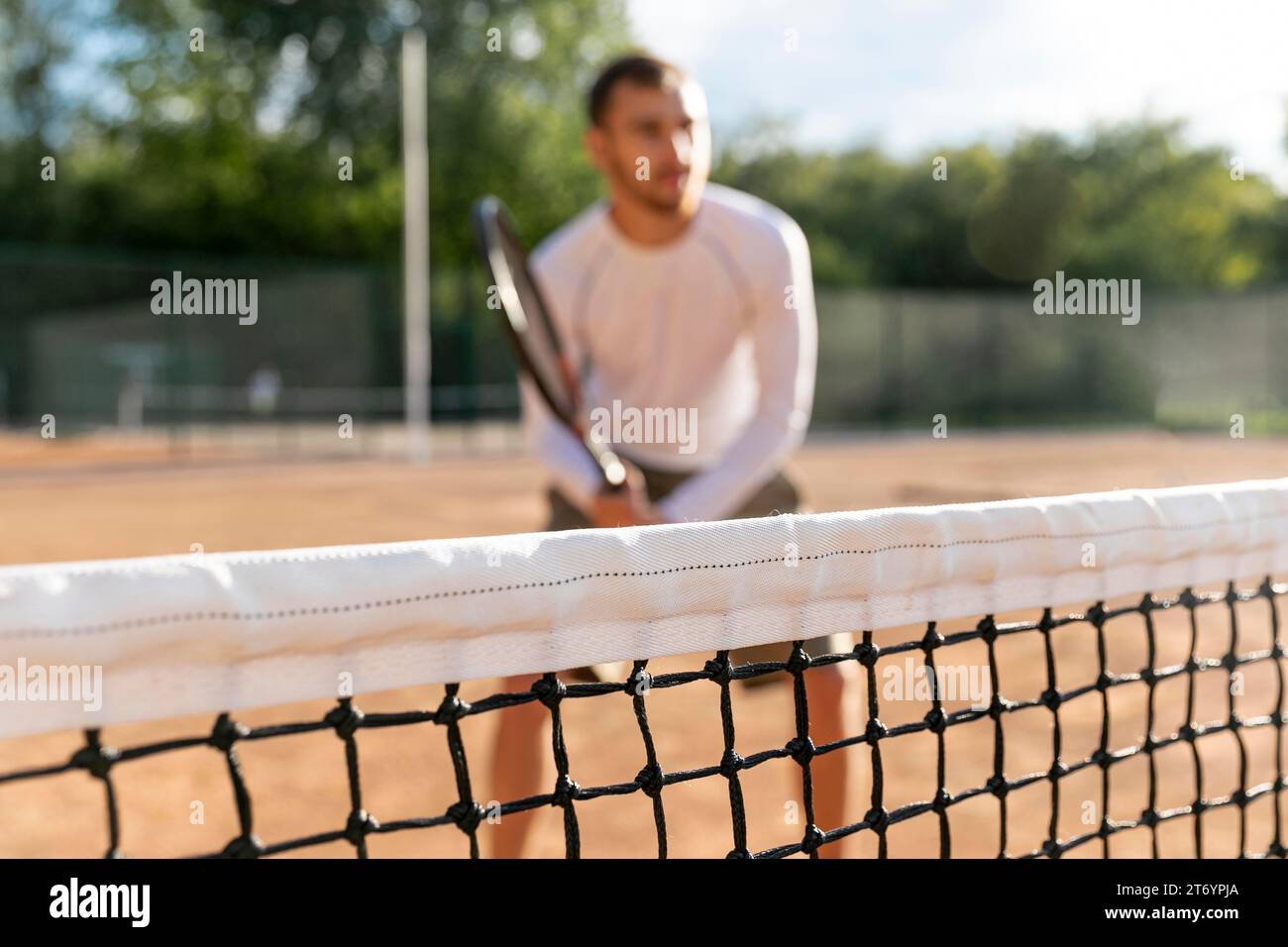 Close up net with defocused man playing tennis Stock Photo