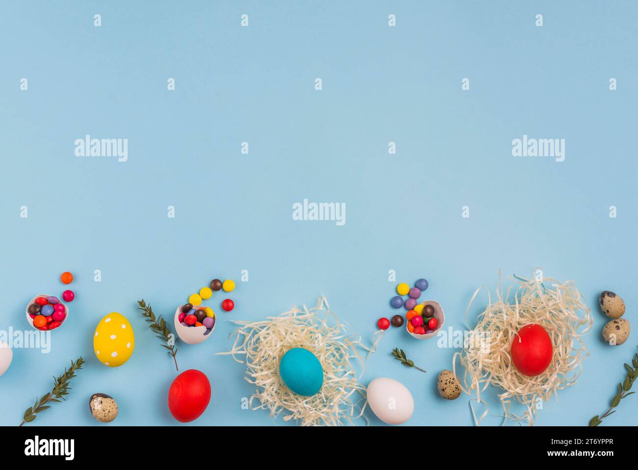 Colored eggs nests with small candies table Stock Photo
