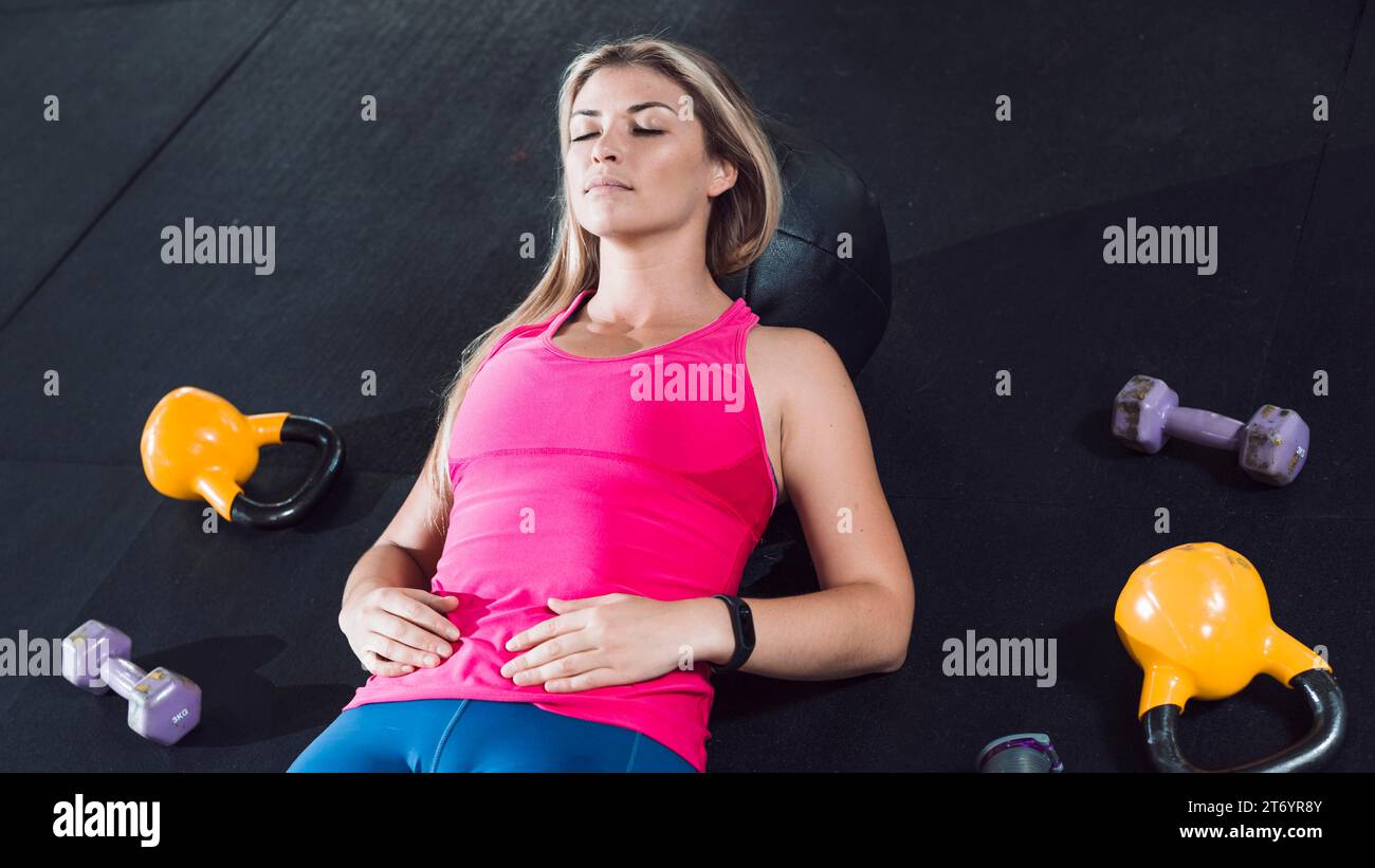 Fit woman resting floor near exercise equipments Stock Photo
