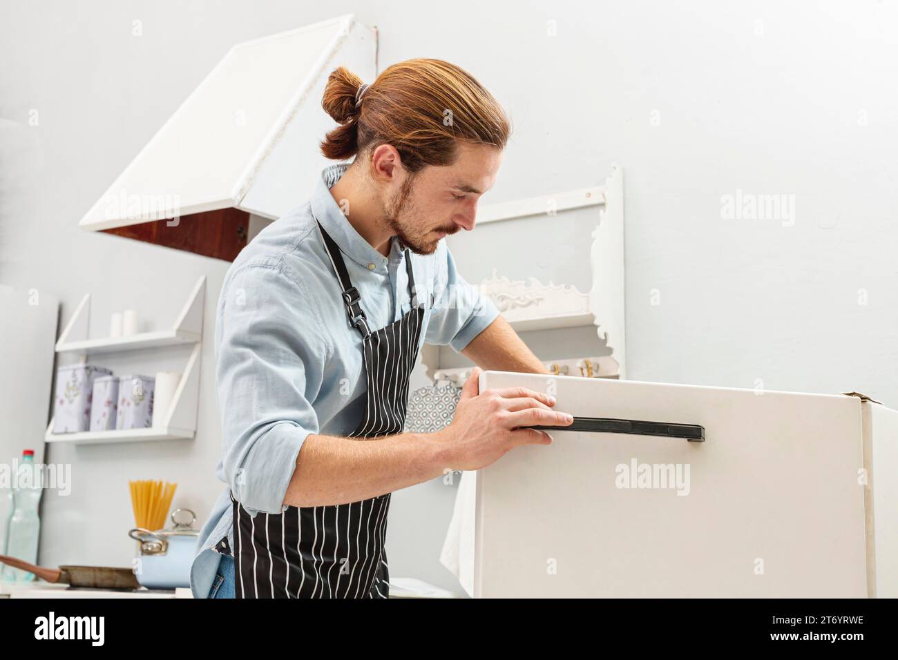 Handsome young man opening fridge Stock Photo