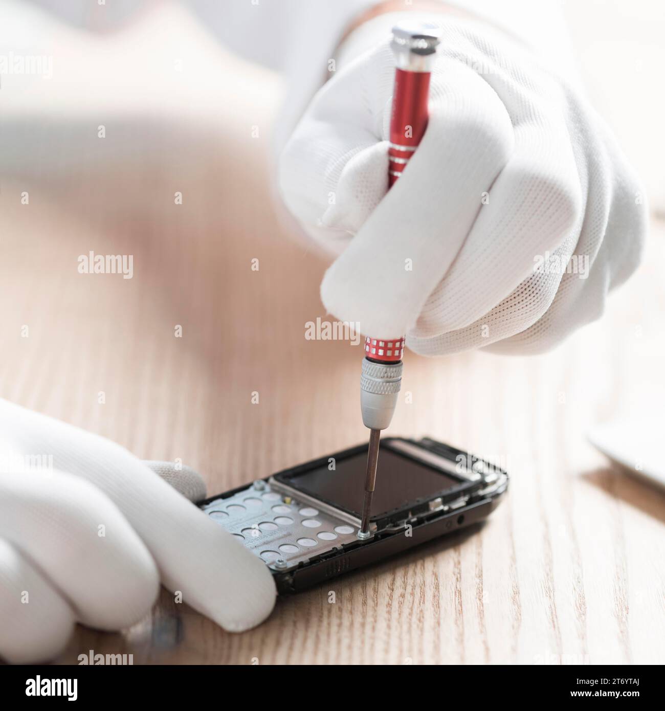 Male technician wearing gloves repairing cellphone Stock Photo